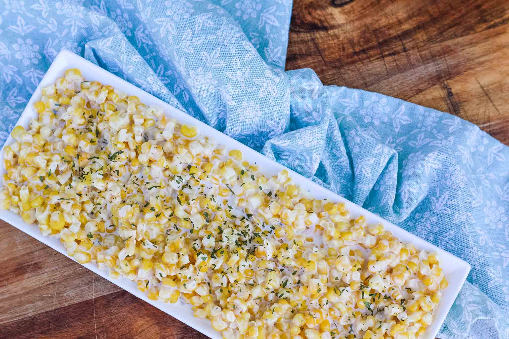 cream cheese corn on rectangle dish with blue dish towel
